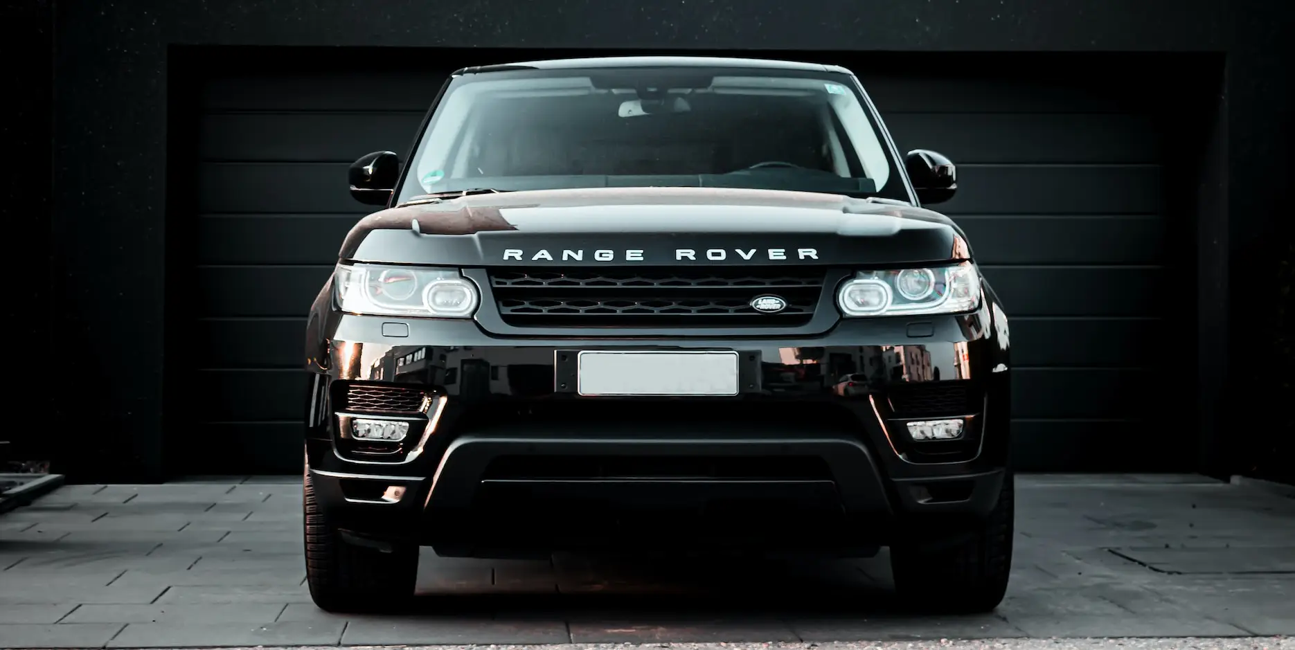 black range rover parked in front of a black garage door