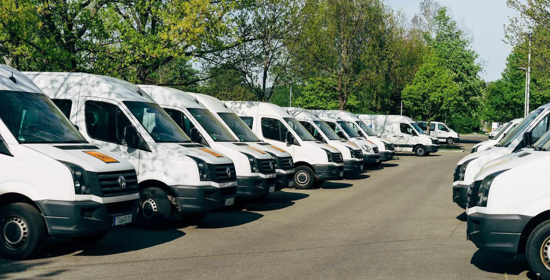 fleet of white vans parked in two lines